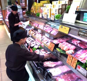 店舗でのOJTの様子 - 精肉の陳列